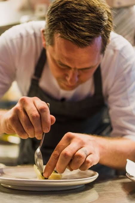 Chef Nic Vanderbeeken finishing a plate by hand